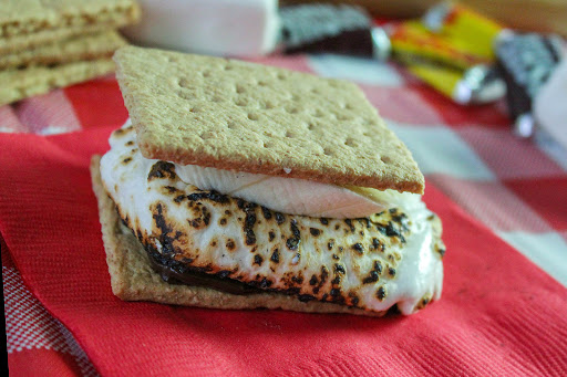 An assembled banana s'more on a red napkin.