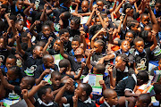 Children at the Es'kia Mphahlele Community Library revel in a new story and the day's events.