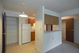 Kitchen with laminate floors, fridge, wood cabinets, white walls, white trim