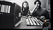 Steve Jobs in front of screen showing him with Steve Wozniak in the early days. 