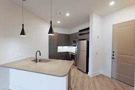 Kitchen with gray cabinets, wood floors and stainless apliances.