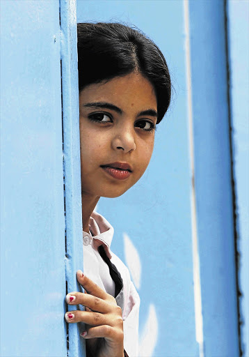 A Palestinian refugee peers from a door at a refugee camp in southern Lebanon Picture: ALI HASHISHO/REUTERS