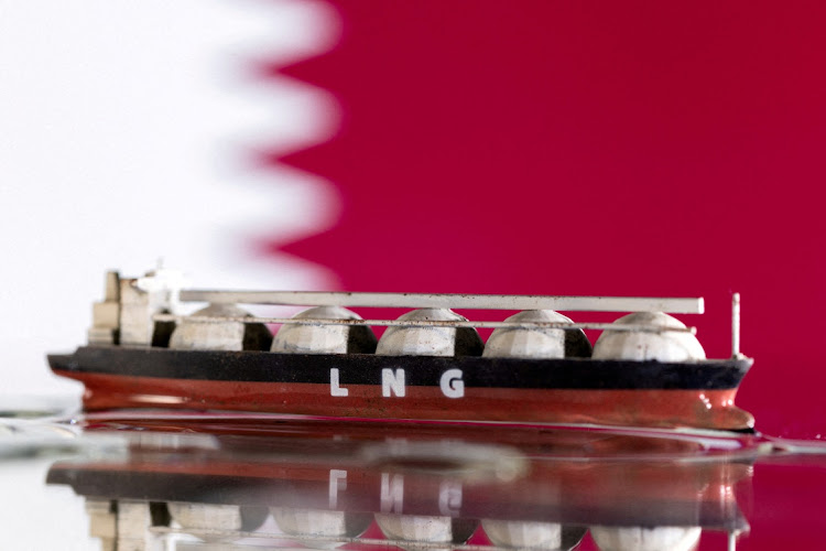 A model of an LNG tanker is seen in front of Qatar’s flag in this file illustration. REUTERS/DADO RUVIC