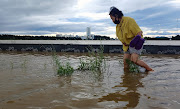 A woman walks on a submerged street as Typhoon Maysak hit Gangneung, South Korea, September 3, 2020. 