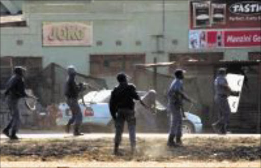 IN FLAMES: Police on their toes as residents block roads and burn several government and private buildings in Mashishing. Pic: ANDREW HLONGWANE. © Sowetan.