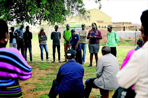 Residents gather under a tree outside the Disaneng tribal offices to voice their displeasure about their chief and his handling of community affairs. Photo: Tiro Ramatlhatse