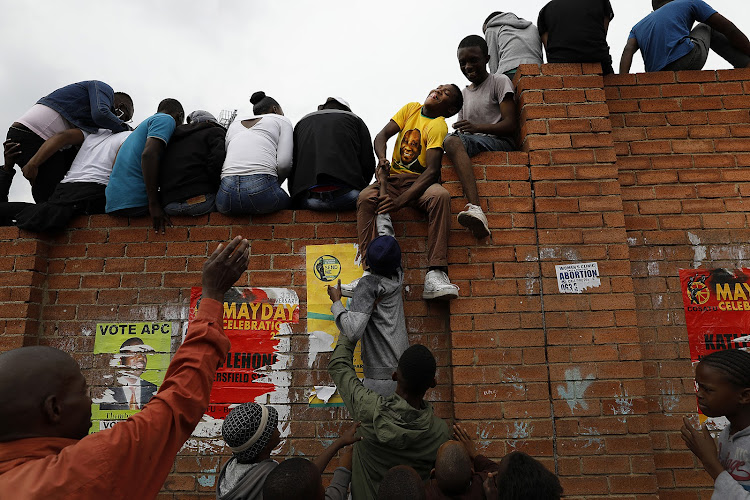 Residents of Alexandra try to find the best seats as ANC president Cyril Ramaphosa visits the Johannesburg township on April 11 2019.