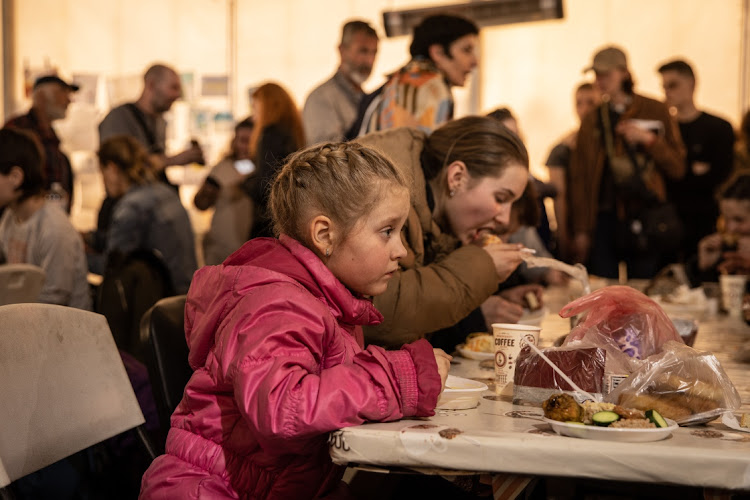 A girl eats in a reception tent after arriving at an evacuation point for people fleeing the Azovstal plant, Mariupol, Melitopol and the surrounding towns under Russian control on May 3 2022 in Zaporizhzhia, Ukraine.