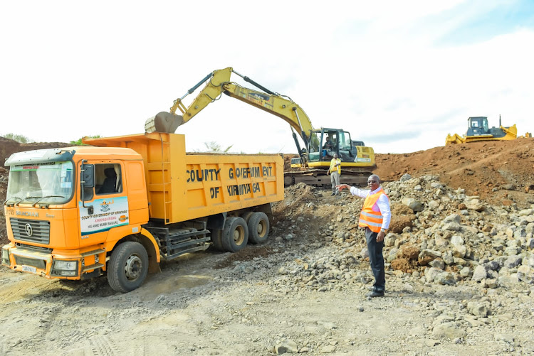 A truck and an excavator at work during an inspection f one of the road being graded in Kirinyaga county on Friday