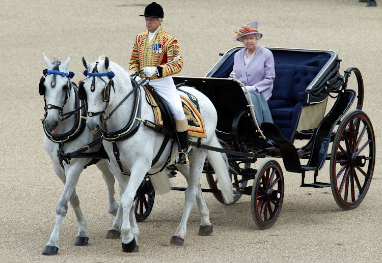 Queen Elizabeth rides in an open carriage as she attends the Trooping the Colour ceremony in London. Picture: REUTERS/Luke MacGregor