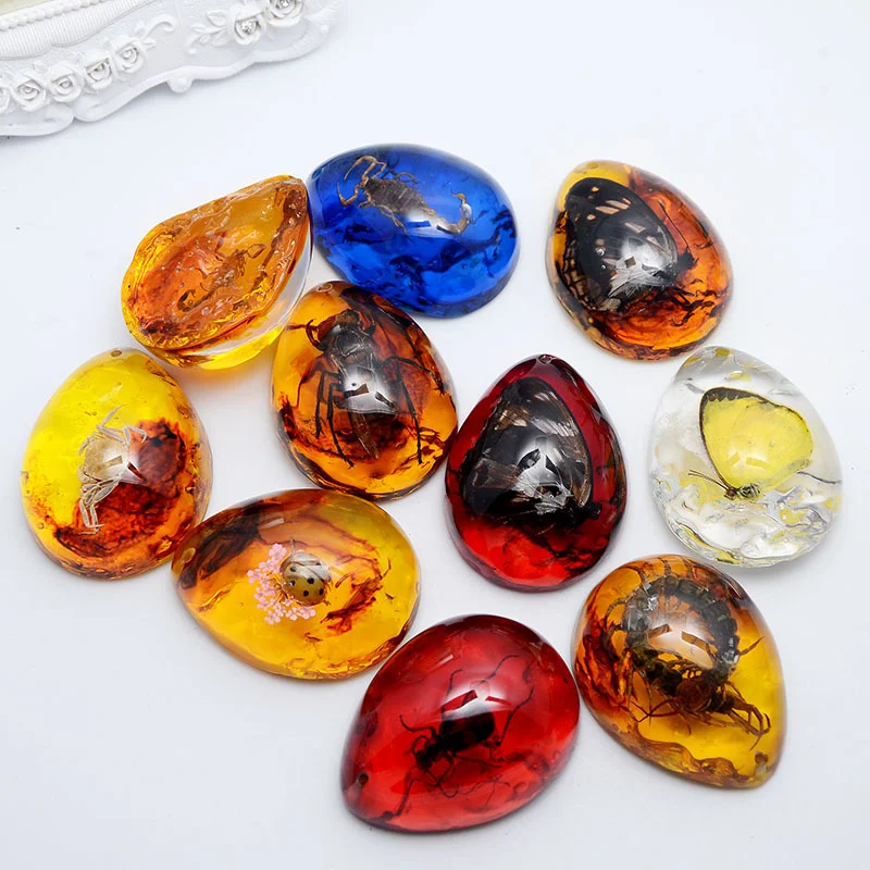 Pendentif en ambre avec insecte et cire d'abeille en forme de goutte. Ornez-vous d'un spécimen naturel unique, élégant et raffiné, idéal pour un cadeau.