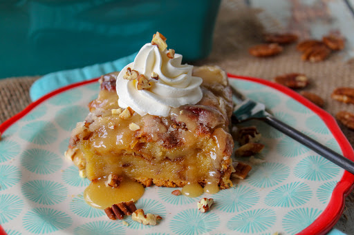 A slice of Drunk Pecan Pie Bread Pudding with extra sauce and whipped cream.