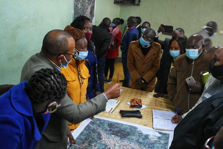 Local leaders and planners from the Mnistry of Lands and Physical Planning from the national government and their Nyeri government counterparts consult during the review of boundaries in Othaya town on Friday.