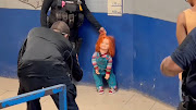 A police officer holds the handcuffed 'demon doll' Chucky by its hair after arresting Carlos 'N', a man who used the doll with a knife to rob people, according to local media, in Monclova, Mexico, on September 11 2023, in this screen grab obtained from a handout video. 