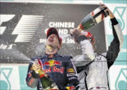 DONE: Red Bull Formula One driver Sebastian Vettel, left, of Germany gets his champagne spray after conquering the rain-soaked China track. 19/04/09. Pic. Andy Wong. © AP.