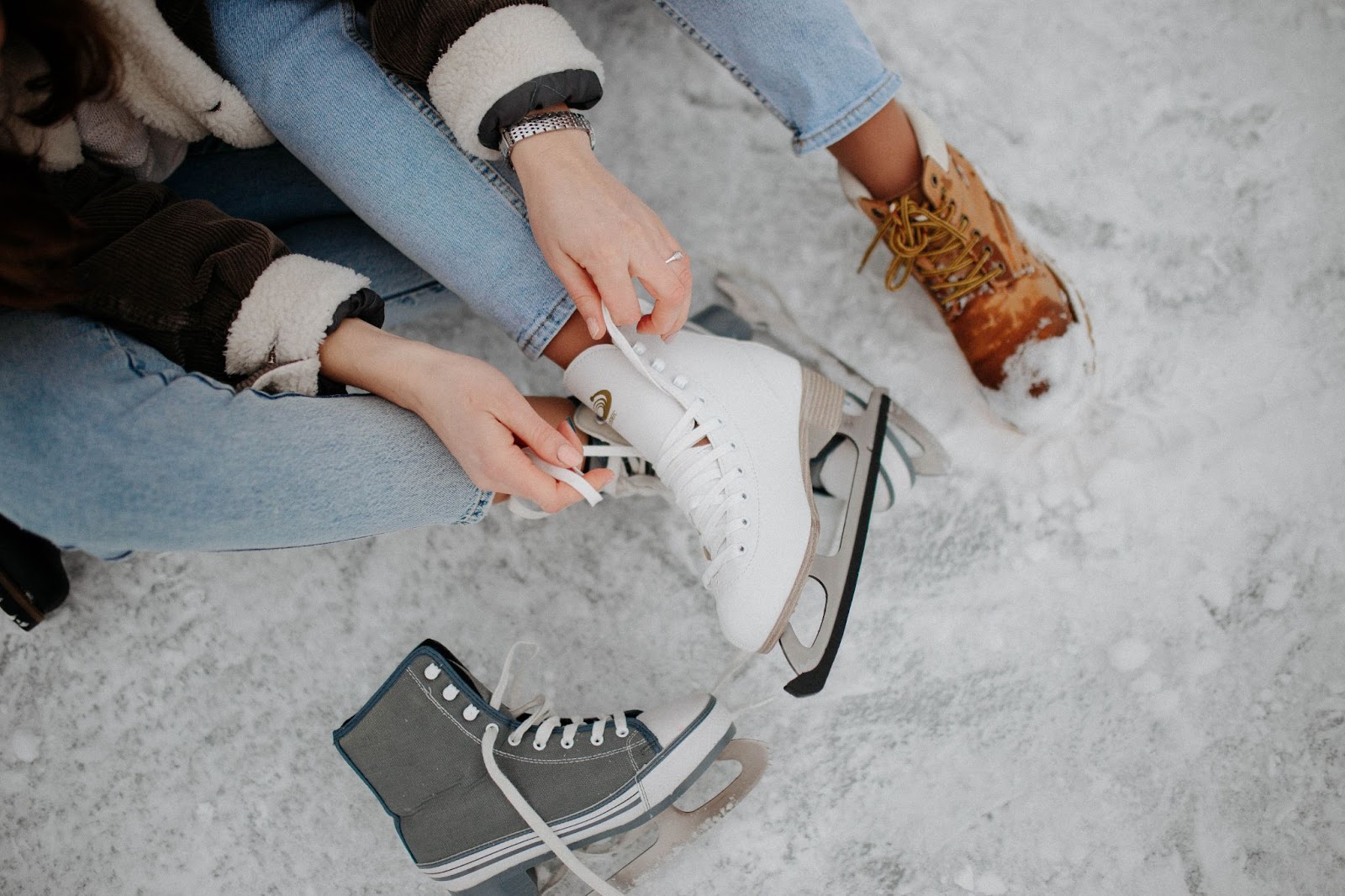 someone lacing up their ice skates at stuart park in kelowna