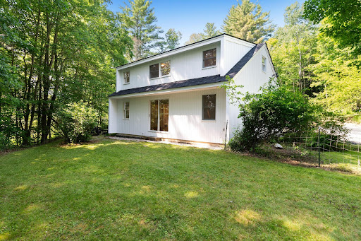 White house with green lawn in this luxury property for sale in Waitsfield ($579,500)