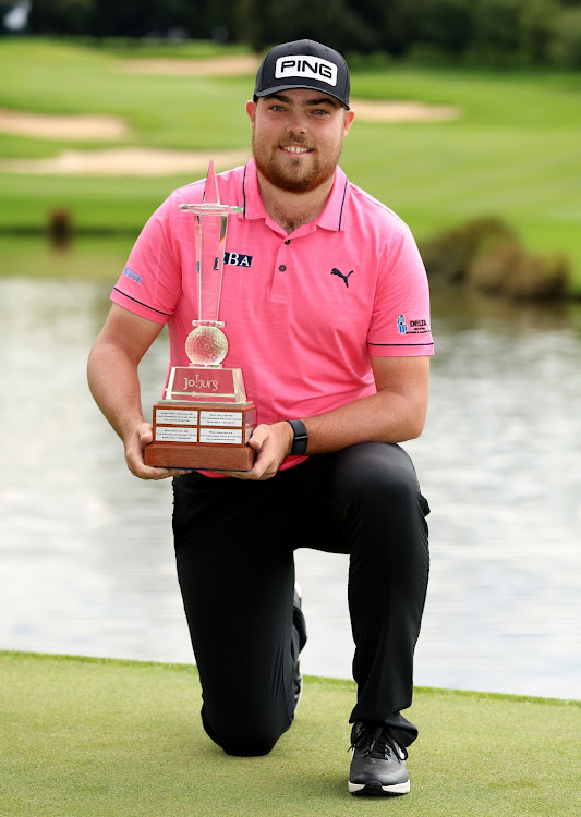 Dan Bradbury of England celebrates with the Joburg Open trophy at the Houghton golf club on Sunday.