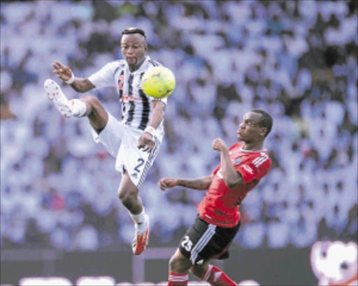 HOSTILE ENVIRONMENT : TP Mazembe's Kimwaki Mpela battles with Orlando Pirates' Rudolf Bester during their Champions League match at TP Mazembe Stadium in Lubumbashi yesterday Photo: BackpagePix