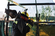 A firefighter makes his way out of the crime scene after using the jaws of life to dismantle equipments used in illegal mining operations, 06 July 2023, at Angelo Informal Settlement in Boksburg, Ekurhuleni, it is alleged that gas leaked from a  nitrate oxide canister used by illegal miners to refine their product into gold killing seventeen people. 