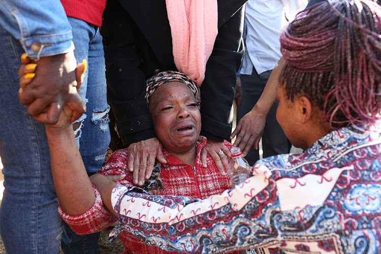 A mother cries after learning her son was stabbed to death outside Forest High School in the south of Johannesburg.
