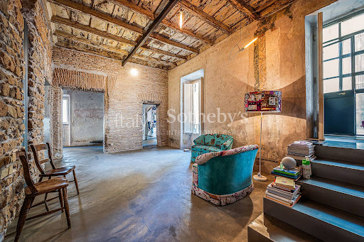 Rustic living room with exposed brick walls in this luxury apartment / penthouse for sale in Rome ($1,274,535 - 126 m²)