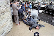 White House Press Secretary James Brady and District of Columbia police officer Thomas Delahanty lie wounded on the ground after John Hinckley Jr. fired six shots at President Ronald Reagan outside the Washington Hilton Hotel in Washington, DC, US on March 30, 1981. 