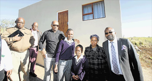 HAPPY DAY: Handing over the keys to their new house in Weza Village in Willowvale yesterday are, from left, correctional services provincial head Nkosinathi Breakfast, advocate Mthunzi Mhaga, beneficiary Zoleka Nakuphi and her children, and Justice and Correctional Services Minister Michael Masutha Picture: LULAMILE FENI