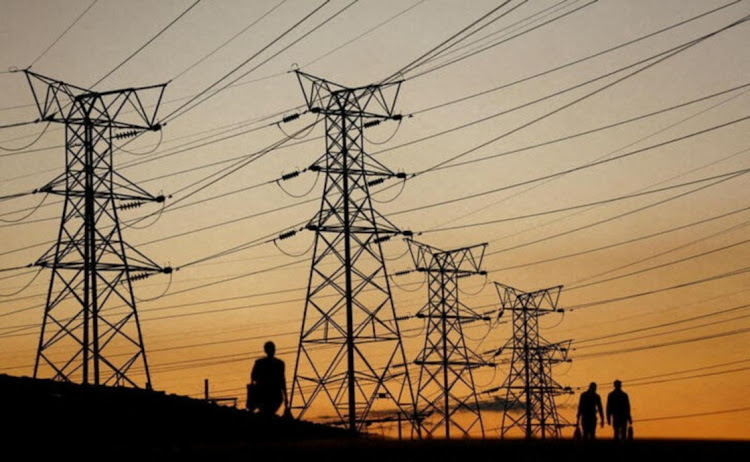 Locals walk past electricity pylons in Soweto, Johannesburg. File photo: REUTERS/SIPHIWE SIBEKO