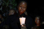 Zinhle Madela, Sphesihle Duma's aunt, holds a candle at a prayer service at the Durban University of Technology. 