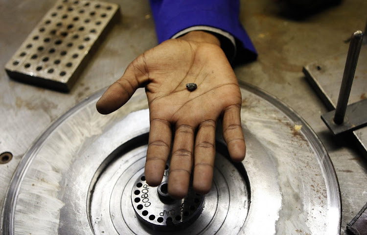 A worker holds a rough diamond from Zimbabwe's Marange diamond fields. File image