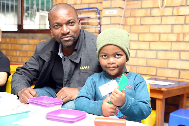 Masonwabe Galadla with his son, Avene, as he gets ready to start grade RR at Cambridge Primary School, East London.