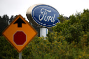 A sign with the Ford logo in front of Serramonte Ford in Colma, California. 