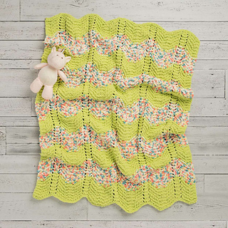 colorful chevron knitted blanket lying on wooden background