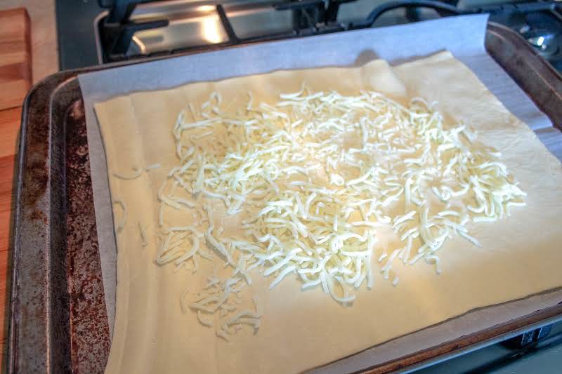 Shredded Mozzarella Sprinkled Over The Dough.