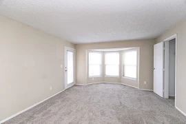 Living room with bay window and plush carpet