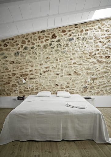 The colours of the stone and wood add a sense of warmth to this minimalist bedroom.