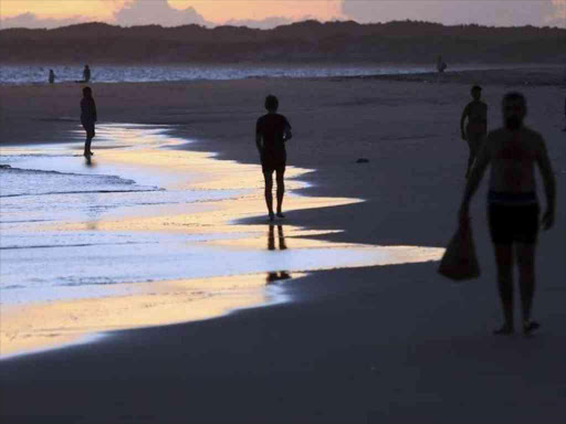 People walk on Shela beach in Lamu, an island in the Indian Ocean off the northern coast of Kenya, March 25, 2013. /REUTERS