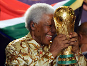 A file photo of the late former South Africa President Nelson Mandela holding the FIFA World Cup trophy exhibition. 
