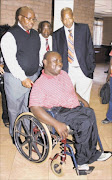 GOOD NEWS: Minister Baloyi pushes a wheelchair-bound man after meeting disabled people. With him is Limpopo MEC for public works George Phadagi.