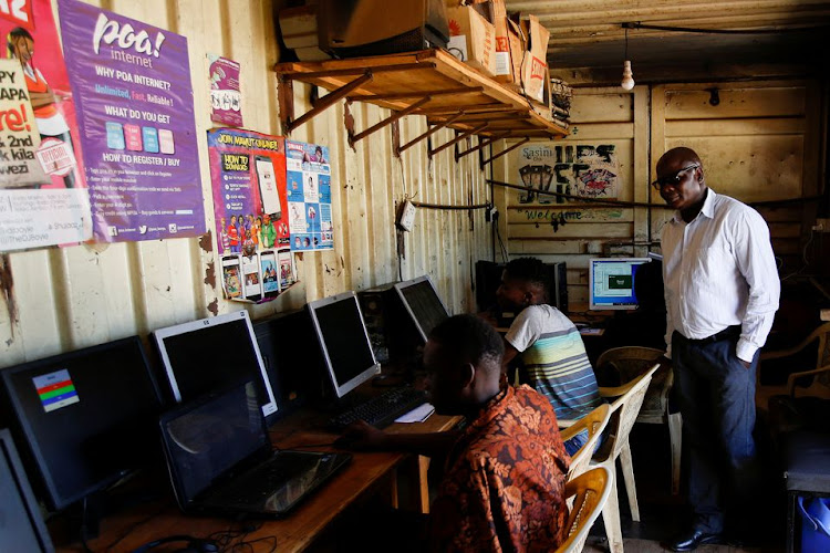 Alfred Ouma stands at his cybercafe business premise, where he uses internet from Poa! Internet provider, in Kibera slum, Nairobi, Kenya, March 23, 2022.