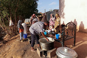 Displaced Sudanese families wait to receive food from a charity kitchen, as a year of war between Sudan's army and the paramilitary Rapid Support Forces (RSF) has driven more than 8.5 million people from their homes, in the city of Omdurman, Sudan, April 6, 2024. 