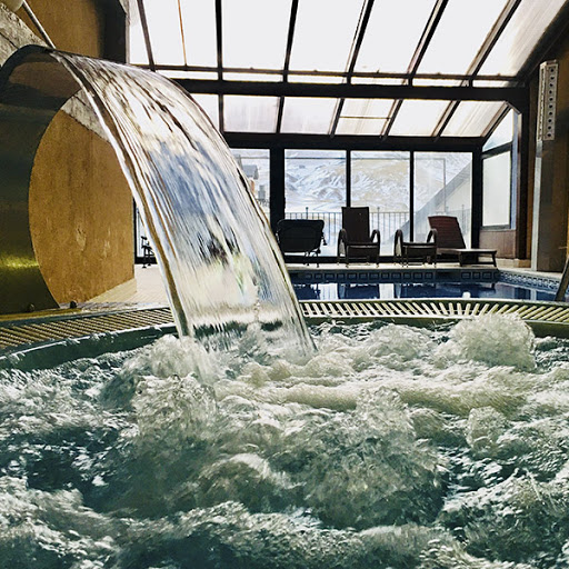 una cascada cae sobre una piscina en un spa