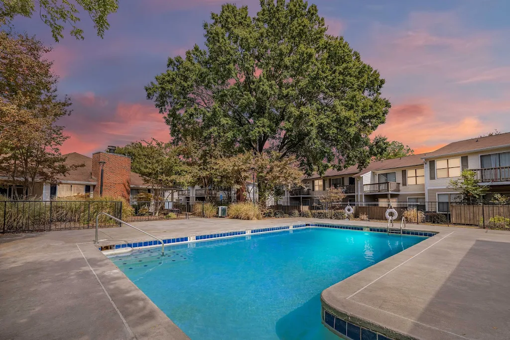 The Boulevard Apartments community pool with trees in the background at dusk