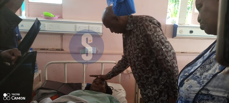 Kenyatta University Vice Chancellor Paul Wainaina comforting an injured student at the Moi County Referral Hospital ward in Voi, Taita Taveta on March 19, 2024