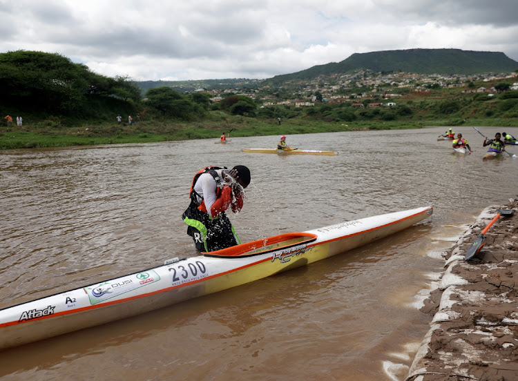 A canoeist washes his face as finishes the first day of the Dusi.