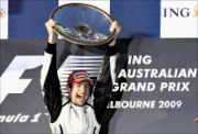 Brawn GP Formula One driver Jenson Button of Britain celebrates winning the Australian F1 Grand Prix in Melbourne in this March 29, 2009 file photo. Formula One's governing body hoped radical new rules would shake up the sport this year and, more emphatically than anyone could imagine, it has got what it wished for.  To match feature MOTOR-RACING/CHANGES   REUTERS/Mick Tsikas/Files    (AUSTRALIA SPORT MOTOR RACING)