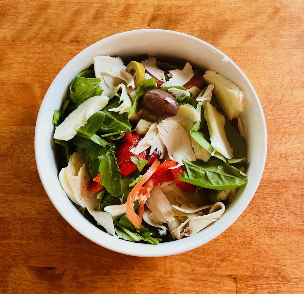 Signature Salad: roast chicken, mixed greens, tomatoes, roasted sweet peppers, artichokes, olives and fresh mozzarella with creamy garlic & herb dressing.