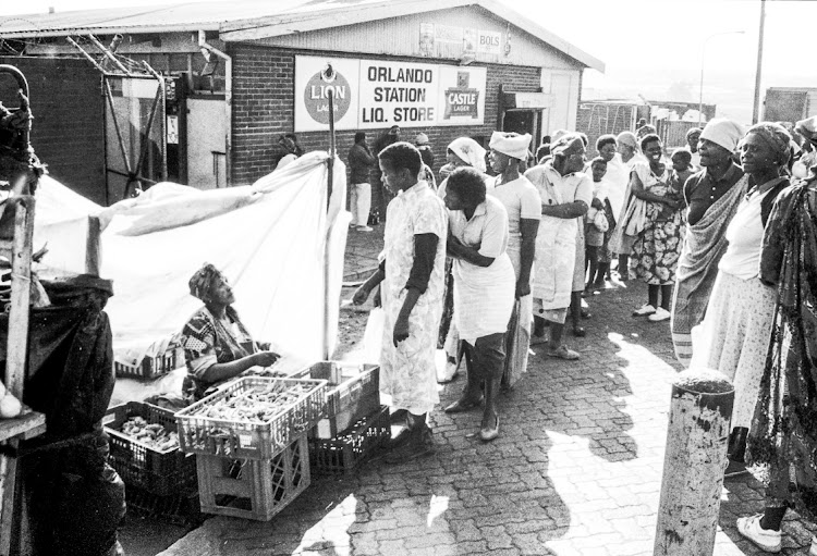 Women queue for chicken feet meant for the evening's dinner at the Orlando train station in the late afternoon.