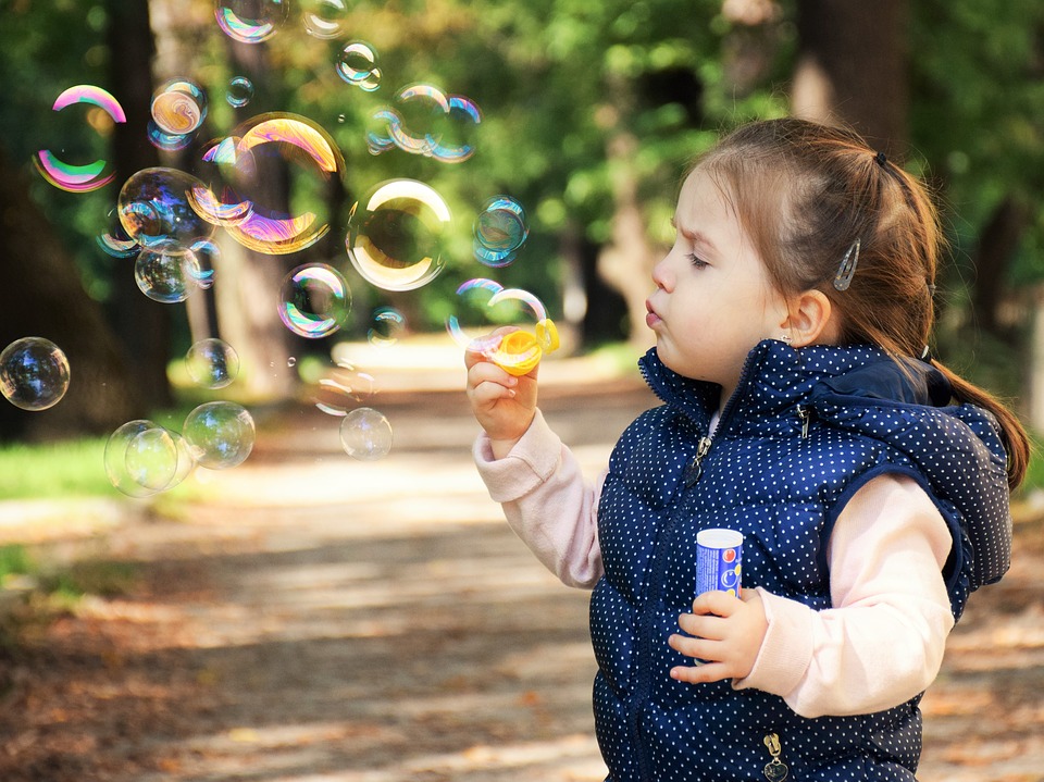 a toddler blowing bubbles